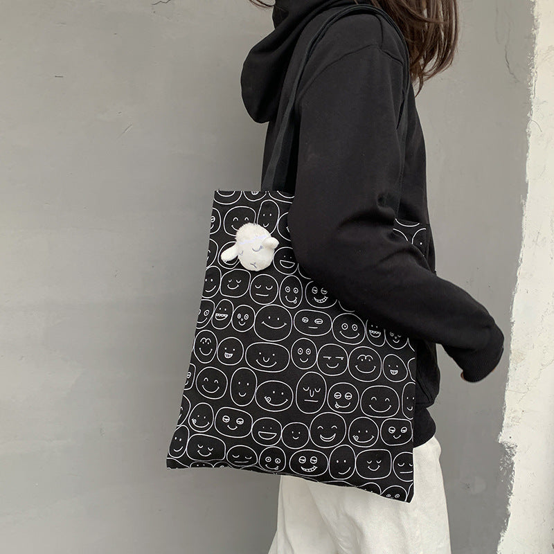 Black tote bag with white smiley face pattern