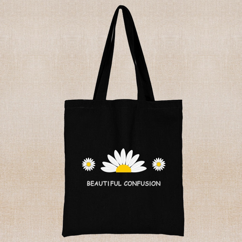 Black tote bag with white and yellow daisy design