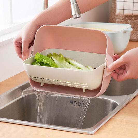 Collapsible silicone colander in pink and light green for kitchen sinks