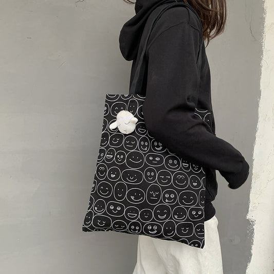 Black tote bag with white smiley face pattern