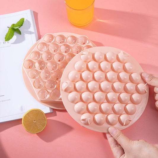 Circular silicone ice cube tray in light pink with dome-shaped compartments