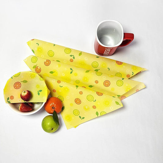 Yellow beeswax food wraps with fruit patterns in use