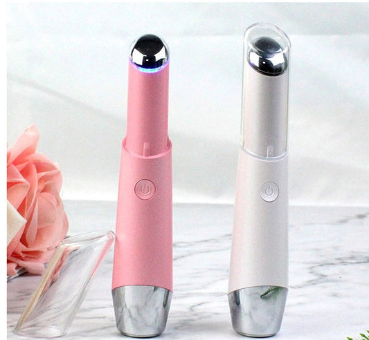 Pink and white reusable facial massager with a cylindrical shape and rounded top